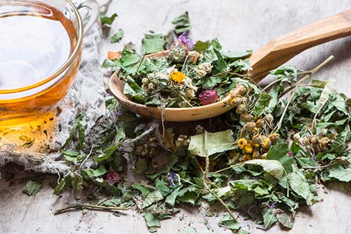 cup of herbal tea with a spoon of herbs